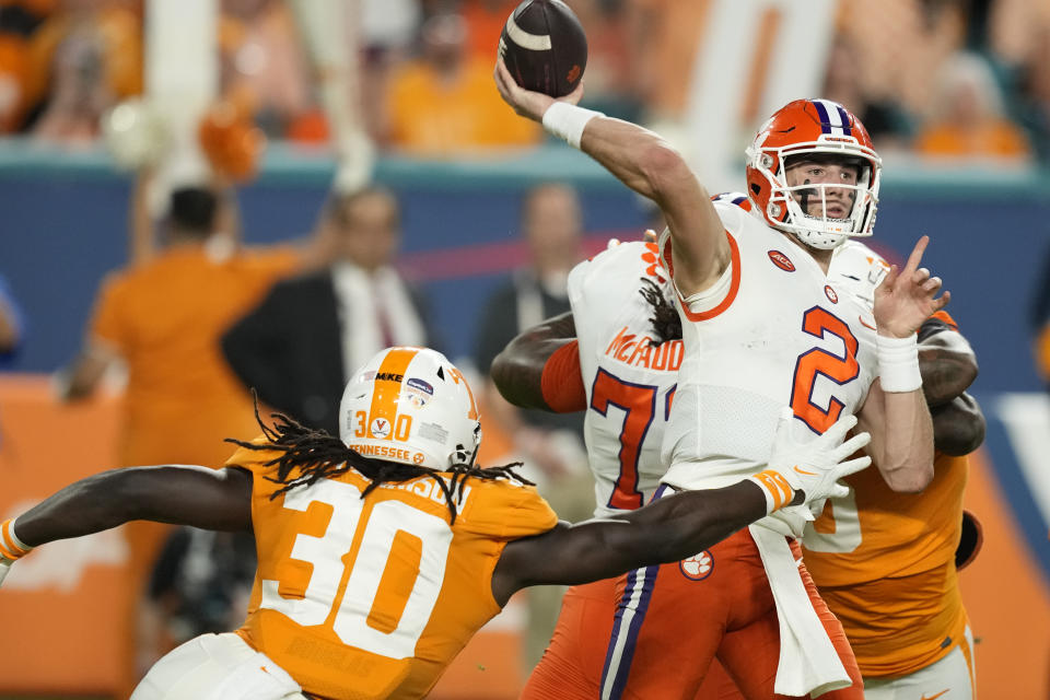 Clemson quarterback Cade Klubnik (2) passes under pressure from Tennessee defensive lineman Roman Harrison (30) during the first half of the Orange Bowl NCAA college football game, Friday, Dec. 30, 2022, in Miami Gardens, Fla. (AP Photo/Rebecca Blackwell)