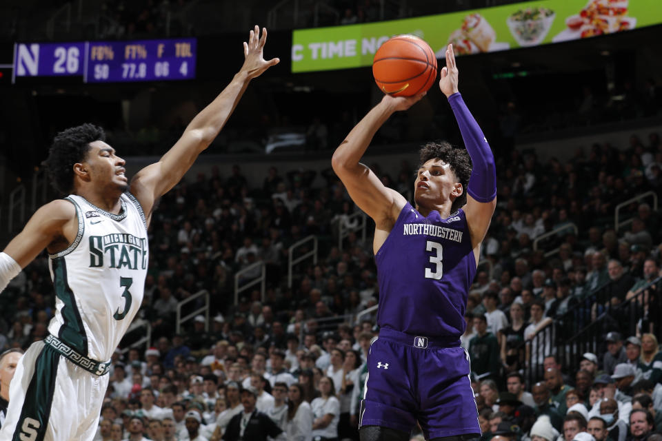 Northwestern's Ty Berry, right, shoots against Michigan State's Jaden Akins during the first half of an NCAA college basketball game, Sunday, Dec. 4, 2022, in East Lansing, Mich. (AP Photo/Al Goldis)