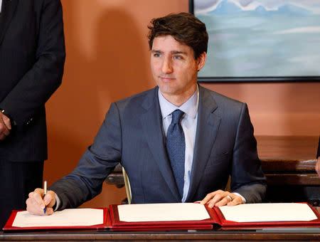 FILE PHOTO: Canadian Prime Minister Justin Trudeau signs a book as he shuffles his cabinet after the resignation of Treasury Board President Scott Brison, in Ottawa, Ontario, Canada, January 14, 2019. REUTERS/Patrick Doyle