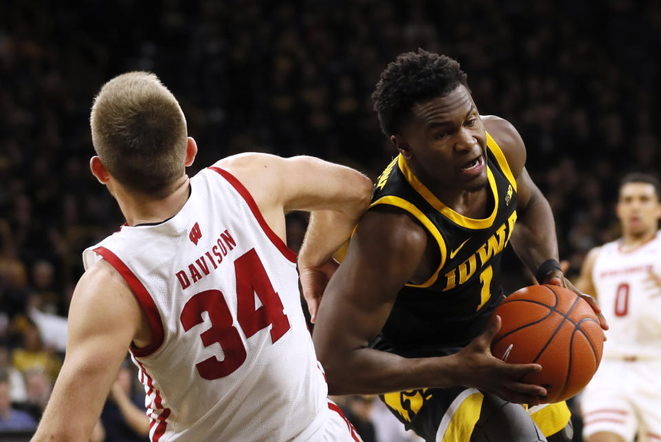 Iowa guard Joe Toussaint is fouled by Wisconsin guard Brad Davison (34) while driving to the basket during the second half of an NCAA college basketball game, Monday, Jan. 27, 2020, in Iowa City, Iowa. Iowa won 68-62. (AP Photo/Charlie Neibergall)