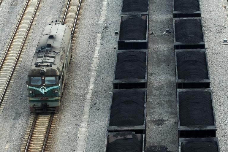 Freight cars (right) filled with coal parked inside a coal mining facility in Huaibei, in northern China's Anhui province on March 5, 2014