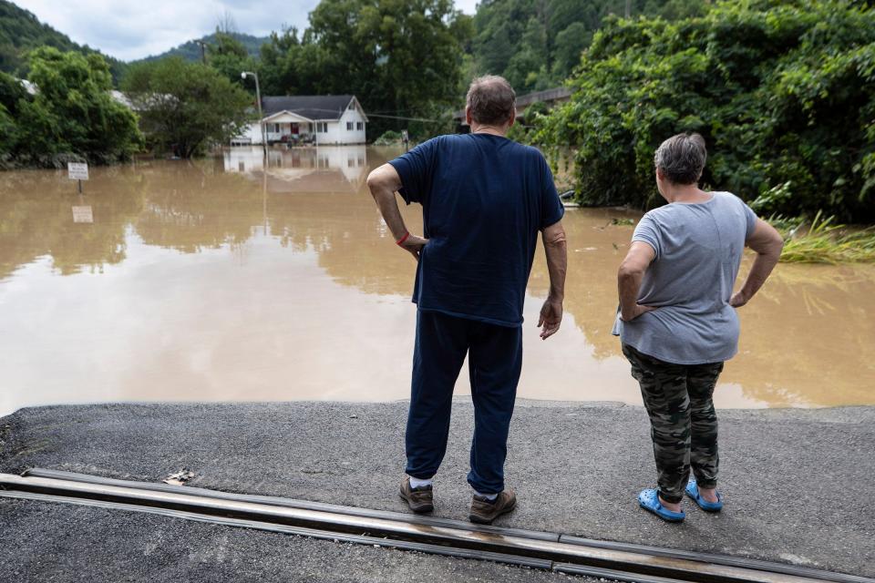 Roger and Loraine Wallen look over flood waters in Garrett, Kentucky. The Wallen's say this is the seance time in 1 1/2 years that their home located near Right Beaver Creek, has flooded. July 28, 2022