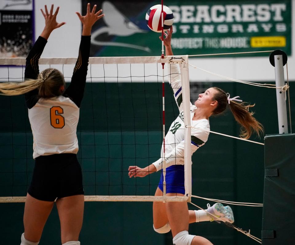 Seacrest Country Day Stingrays hitter Brooke Spurgeon (18) tips the ball over the net as Bishop Verot Vikings Diana Ahkmetova (6) goes for a block during the season opener at Seacrest Country Day in Naples on Tuesday, Aug. 22, 2023.