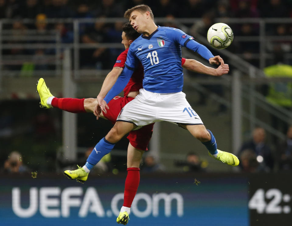 Portugal's Mario Rui, left, and Italy's Nicolo Barella jump for the ball during the UEFA Nations League soccer match between Italy and Portugal at the San Siro Stadium, in Milan, Saturday, Nov. 17, 2018. (AP Photo/Antonio Calanni)