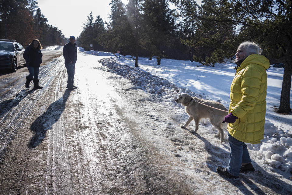 Kristin Kasinskas, left, husband, Peter, and Jeanne Nutter and her dog Henry head back to their homes after speaking with the media Friday, Jan. 11, 2019, in Gordon, Wis. Kristin Kasinskas called 911 on Thursday, to report that Jayme Closs, 13, had been found after Nutter, who was out walking her dog, encountered her and brought her to Kasinskas' house. Closs went missing in October after her parents were killed. (Richard Tsong-Taatarii/Star Tribune via AP)