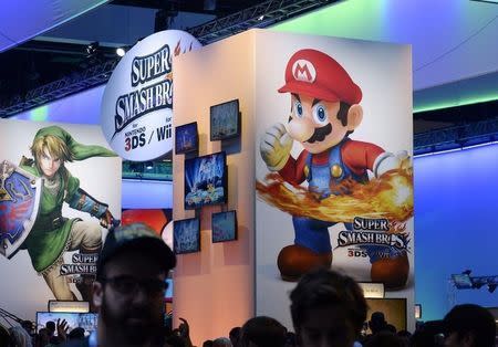 Attendees walk past Nintendo Co.'s Super Smash Bros. signage at the 2014 Electronic Entertainment Expo, known as E3, in Los Angeles, California June 11, 2014.REUTERS/Kevork Djansezian