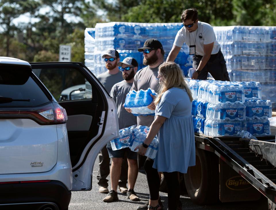 Midway Water System and Florida Department of Environmental Protection employees loaded bottled water into cars of Soundside Dr. residents on Friday, Oct. 22, 2021. The water distribution comes after a contractor mistakenly connected a sewer line to the water main supplying water to some 300 residents along Soundside Drive. 