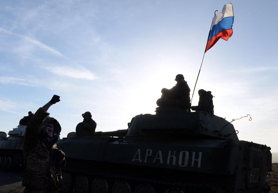 Russian flag flies near Pro-Russia militants sitting atop a 2S1 Gvozdika (122-mm self-propelled howitzer) as a convoy of pro-Russian forces takes a break as they move from the frontline near the eastern Ukrainian city of Starobeshevo in Donetsk region, on February 25, 2015 (AFP via Getty Images)