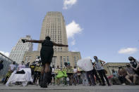 Organizer Stacy Shaw talks to protesters outside city hall Thursday, Oct. 8, 2020, in Kansas City, Mo. Protesters have occupied the lawn and plaza in front of city hall for more than a week demanding the resignation of police chief Rick Smith and an officer who knelt on the back of a pregnant woman while arresting her last week. (AP Photo/Charlie Riedel)