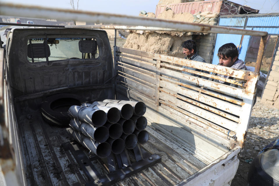 Afghan security personnel stand near a vehicle in which rockets were placed, in the aftermath of a rocket attack in Bagram, north of Kabul, Afghanistan, Saturday, Dec. 19, 2020. Five rockets were fired at a major U.S. base in Afghanistan on Saturday, but there were no casualties, NATO and provincial officials said. (AP Photo/Rahmat Gul)