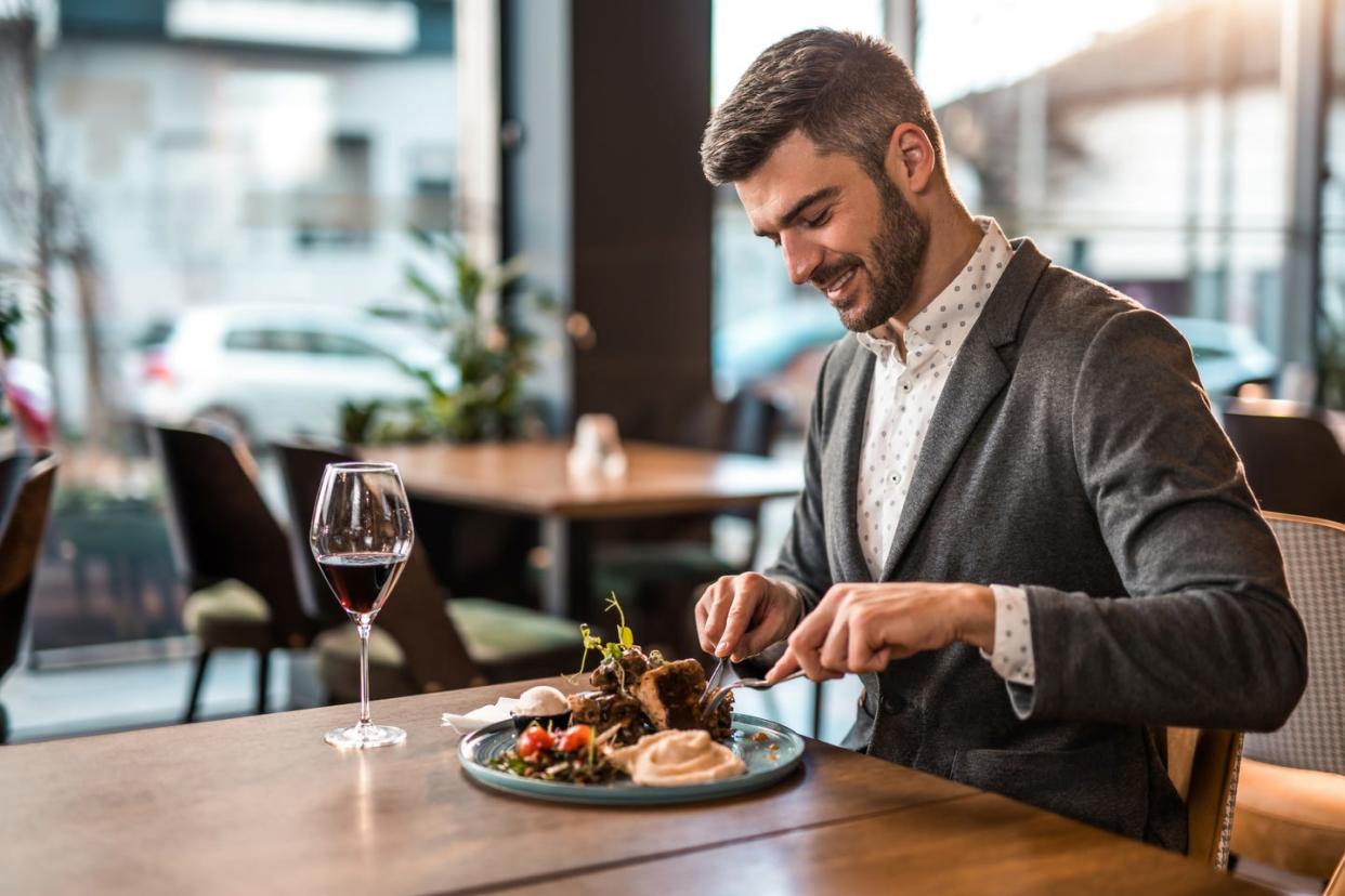 happy young man eating lunch at a restaurant