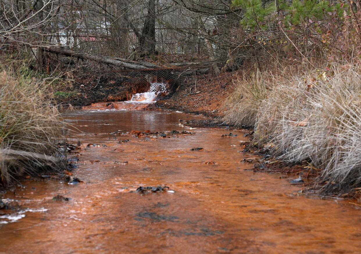Gallons of bright orange, acidic water pour from a 20-square-mile underground coal mine abandoned in 1964 along Truetown Road in Millfield, Athens County, and into Sunday Creek. The smell of sulphur hangs in the air. Two Ohio University professors are working with Rural Action, Inc., and state and federal agencies on an idea to clean the toxins, including iron oxide, from the water in a sustainable way: by turning them into pigment for paint.