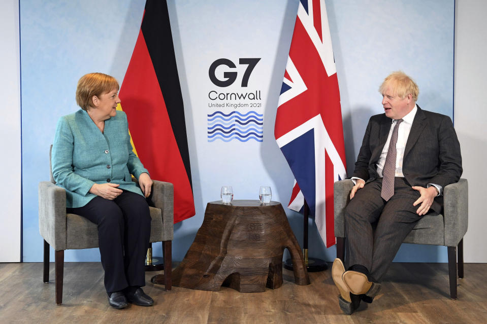 Britain's Prime Minister Boris Johnson, right, and German Chancellor Angela Merkel ahead of a bilateral meeting during the G7 summit in Cornwall, England, Saturday June 12, 2021. (Stefan Rousseau/Pool via AP)