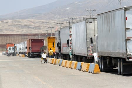 Trucks wait in queue for border customs control at the Otay border crossing in Tijuana