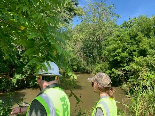 Crews with Dominion Energy look at a portion of Hominy Creek in West Asheville, where the streambanks are eroding and endangering a natural gas pipeline.