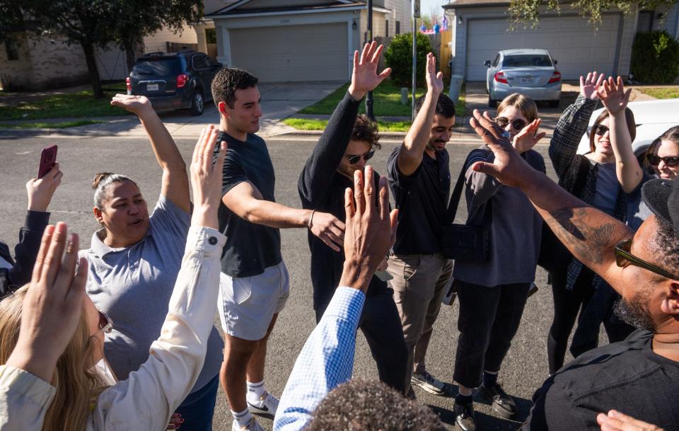 Erica Reyes, left, cheers with volunteers from St. Edward's University as they get fired up for the opinion-gathering effort.