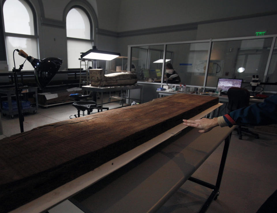 This photo taken Friday, Oct. 19, 2012 shows a hieroglyphic-inscribed slab of wood that comprised part of the coffin of an Egyptian named Ahanakht, circa 2000 B.C. at the Penn Museum in Philadelphia. The newly installed Artifact Lab at the Penn Museum allows visitors to peek behind the scenes as staff members preserve relics from ancient Egypt. Human and animal mummies, as well as the intricately inscribed coffin, are among the items currently undergoing treatment and repair. (AP Photo/Jacqueline Larma)