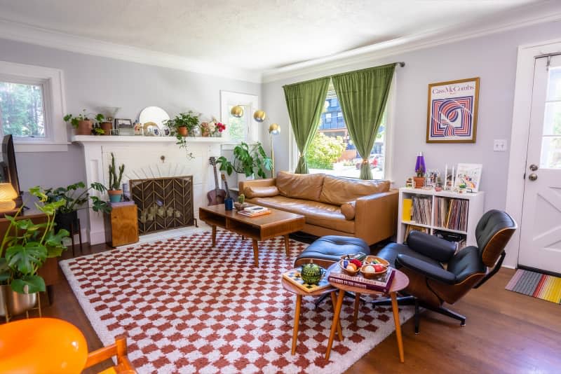 Eclectic living room with pops of color throughout and checkerboard rug on floor.