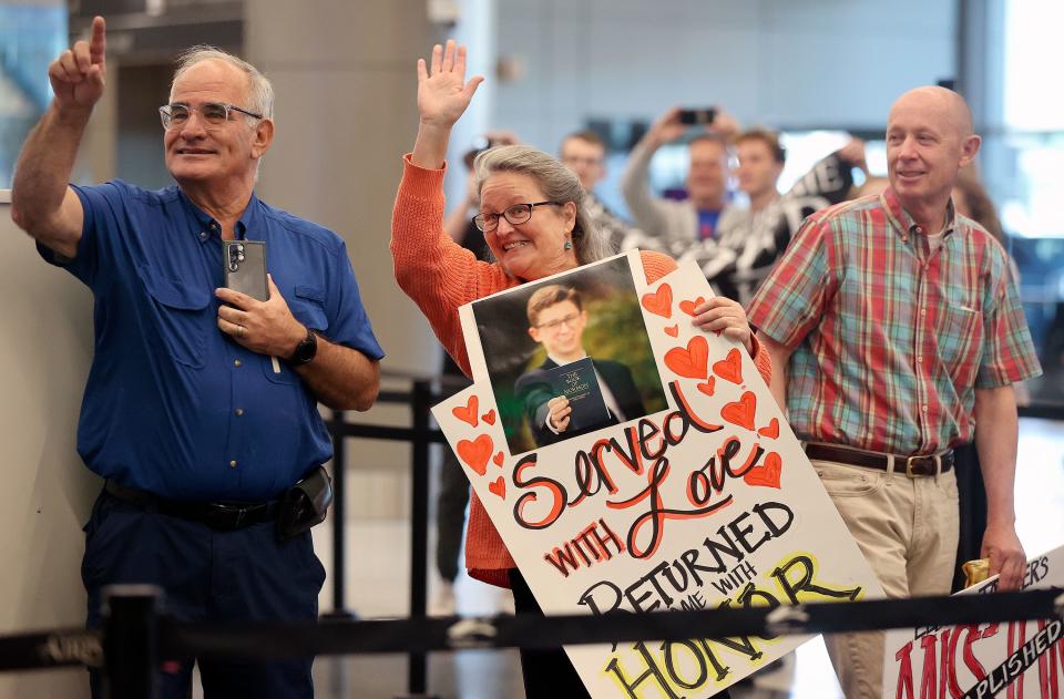 Heidi Tanner holds a sign and looks for her son as people arrive at the Salt Lake City International Airport in Salt Lake City on Tuesday, June 20, 2023. | Kristin Murphy, Deseret News