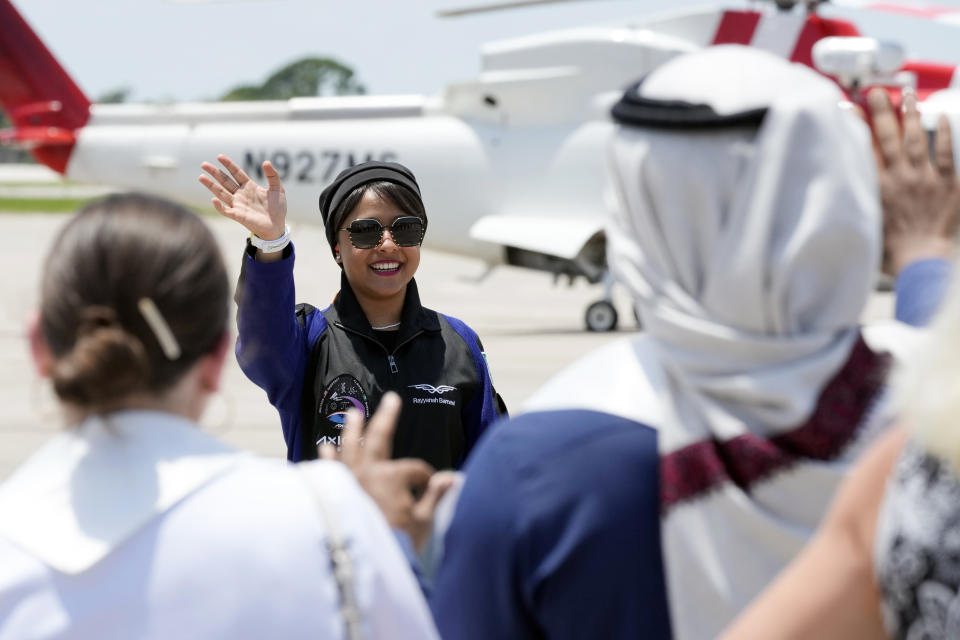 Saudi Arabian astronaut Rayyanah Barnawi waves to family and friends as she arrives at the Kennedy Space Center in Cape Canaveral, Fla., for a scheduled launch Sunday, May 21, 2023. (AP Photo/John Raoux)