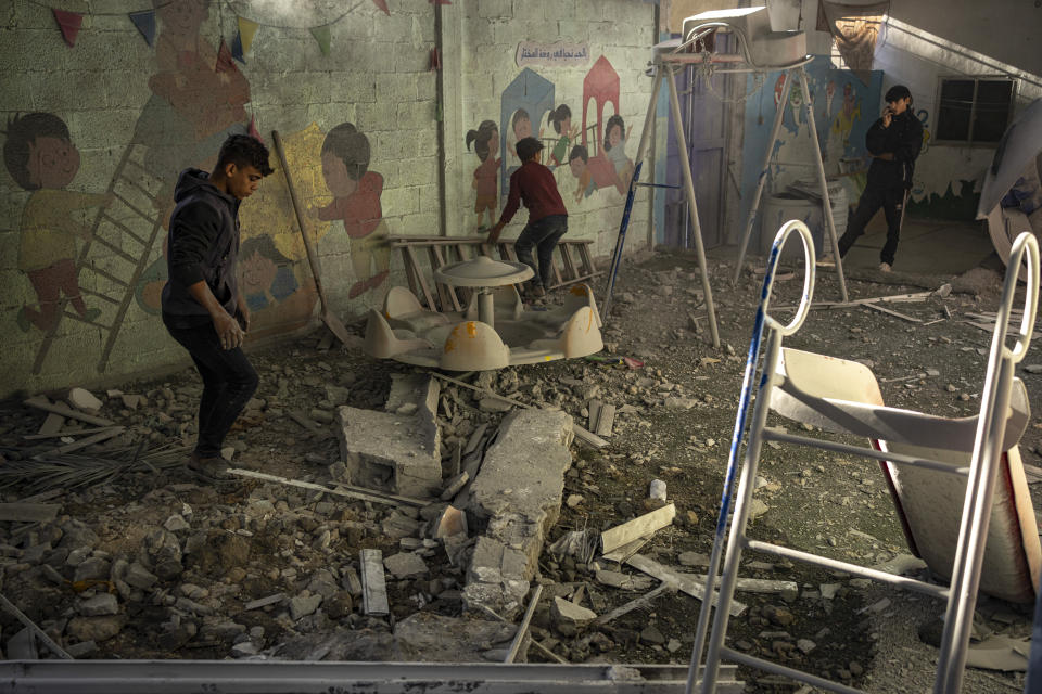 Palestinians look at houses destroyed in the Israeli bombardment of the Gaza Strip in Rafah on Saturday, Dec. 9, 2023. (AP Photo/Fatima Shbair)