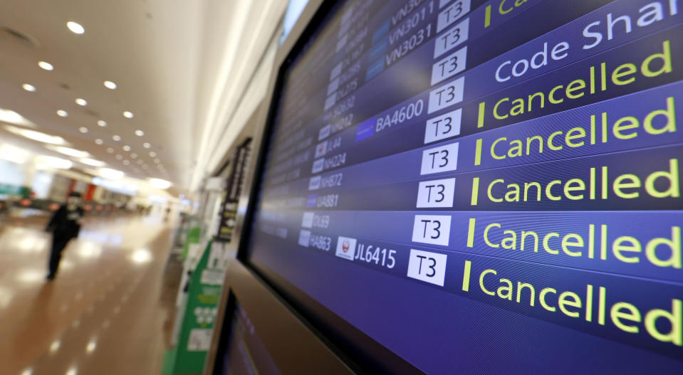 FILE - Flight cancelations are seen on the information board at Haneda Airport in Tokyo, Japan, Tuesday, Nov. 30, 2021. NHK TV said Wednesday, Dec. 1, that Japan will suspend new reservations on all incoming flights for a month to guard against new virus variant. (Shinji Kita/Kyodo News via AP)