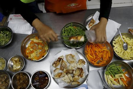 A worker of MyMeals, a food delivery service, prepares dinner for people with diabetes at Cikokol district near Jakarta, Indonesia, April 25, 2016. REUTERS/Beawiharta