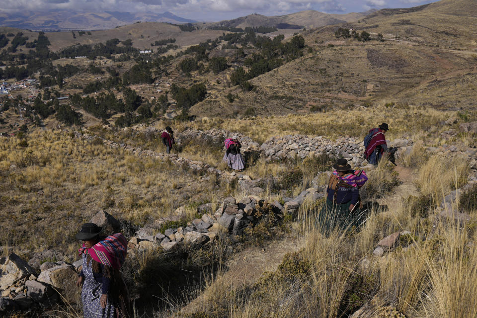 Mujeres indígenas aymaras caminan hacia la montaña sagrada Inca Pucará para un día de oración en un llamado a la lluvia en Chiquipata, Bolivia, el miércoles 16 de noviembre de 2022. (AP Foto/Juan Karita)