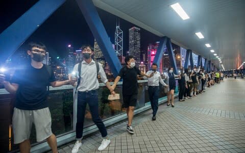 Demonstrators join hands to form a human chain during the Hong Kong Way event in the Central district - Credit: Bloomberg