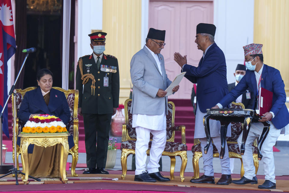 Nepal's former prime minister Sher Bahadur, second right, greets newly elected prime minister Pushpa Kamal Dahal, center, after Dahal was sworn in by President Bidhya Devi Bhandari, left, during a ceremony at the President House in in Kathmandu, Nepal, Monday, Dec. 26, 2022. Dahal has appointed three deputies and four other ministers in the Cabinet that is expected to be expanded in the next few days to accommodate more members from the seven parties in the new coalition government. (AP Photo/Niranjan Shrestha)