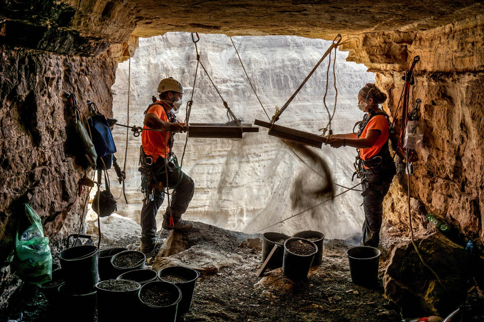 Image: Archeologists Hagay Hamer and Oriah Amichai sifting finds at the Horror Cave. (Eitan Klein / Israel Antiquities Authority)