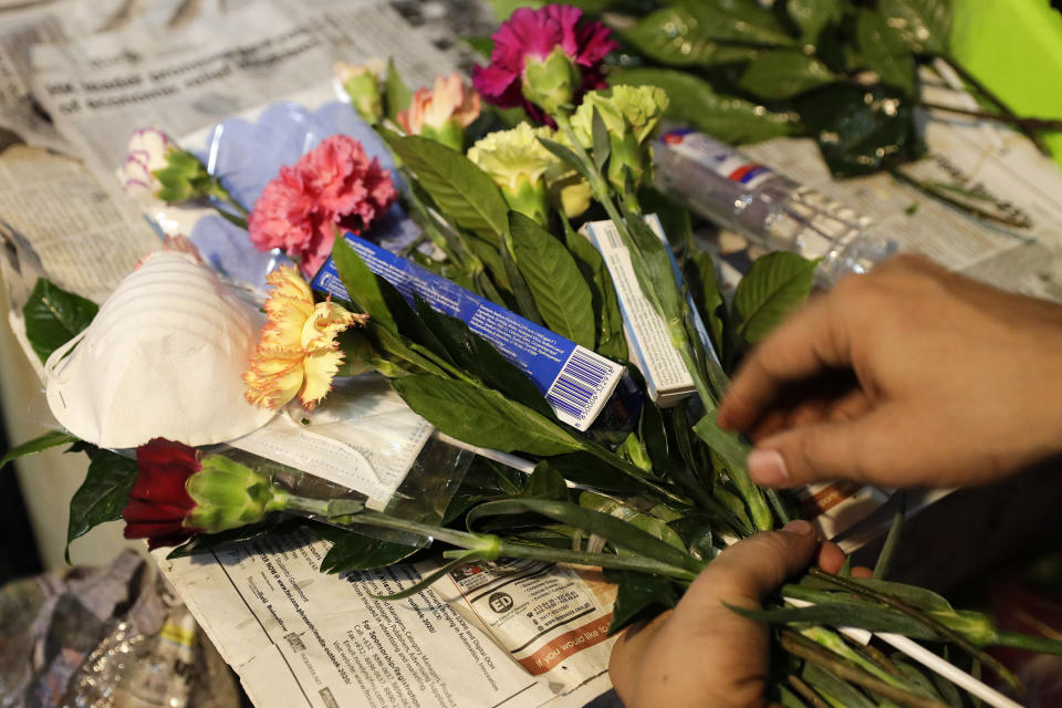 A man arranges a Valentines flower arrangement which they called "anti-nCoV bouquet" in Alabang, metropolitan Manila, Philippines Thursday, Feb. 13, 2020. Shop owner Mary Jane Villegas said she placed protective face masks, alcohol, soap, toothpaste and gloves in her bouquet to remind people that flowers are not the only things you can give during Valentines but also protection against the COVID-19. The "anti-nCoV" bouquet is sold for P1,300, or U.S.$26. (AP Photo/Aaron Favila)