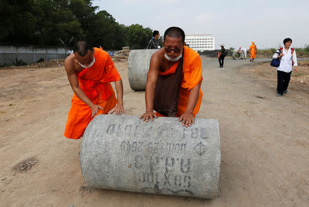 Buddhist monks set up a barricade at one of the gates of Dhammakaya temple to block soldiers who are outside the gate from accessing the temple in Pathum Thani province, Thailand February 23, 2017. REUTERS/Chaiwat Subprasom