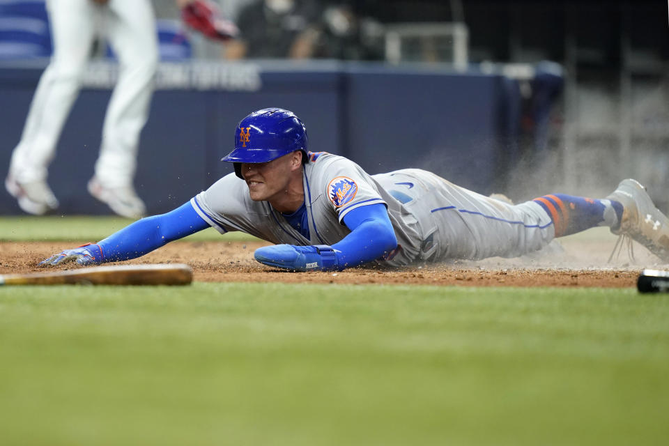 New York Mets' Brandon Nimmo scores on a double by Francisco Lindor during the sixth inning of the team's baseball game against the Miami Marlins, Friday, June 24, 2022, in Miami. (AP Photo/Lynne Sladky)