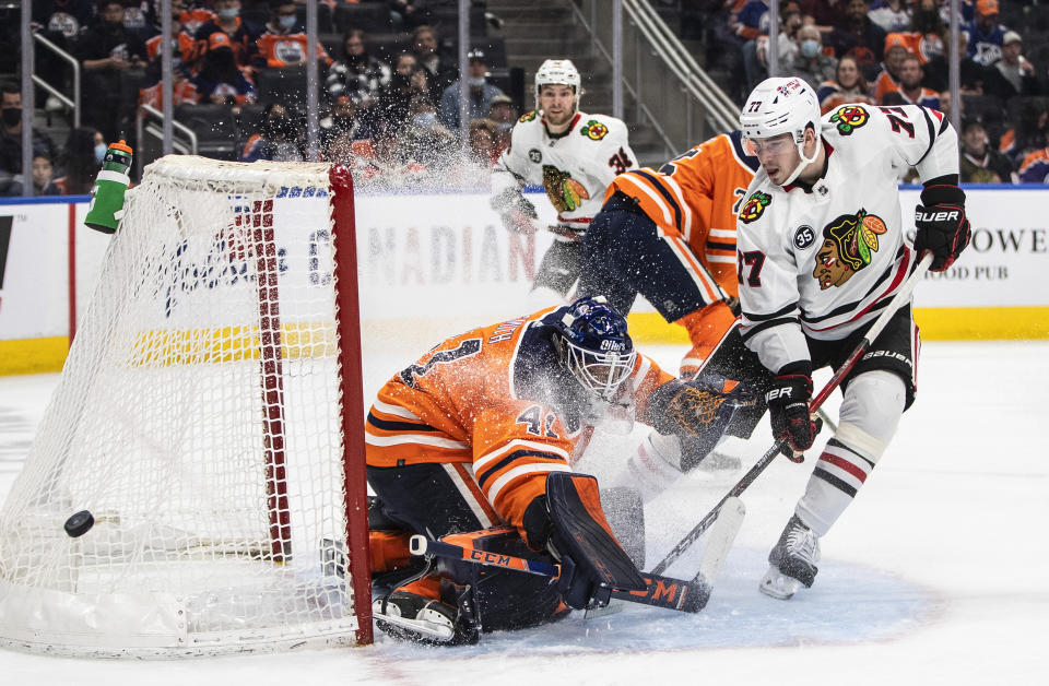 Chicago Blackhawks' Kirby Dach (77) is stopped by Edmonton Oilers goalie Mike Smith (41) during the first period of an NHL hockey game Wednesday, Feb. 9, 2022, in Edmonton, Alberta. (Jason Franson/The Canadian Press via AP)