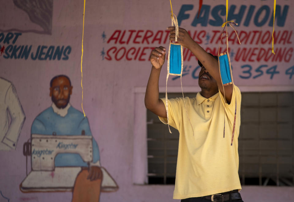 A man hangs selfmade face masks at his stall on the street in Diepsloot, north of Johannesburg, South Africa, Thursday, April 16, 2020. South African President Cyril Ramaphosa extended the lockdown by an extra two weeks in a continuing effort to contain the spread of COVID-19. (AP Photo/Themba Hadebe)