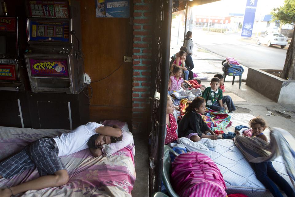 People lie on mattresses outside a store near their homes after several earthquakes in Managua, Nicaragua, just after sunrise Monday, April 14, 2014. The government is recommending people sleep outside after an earthquake occurred a bit further away from Managua Sunday morning, following quakes on Thursday and Friday. (AP Photo/Esteban Felix)