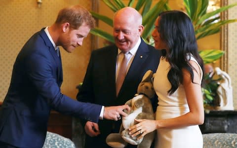 Britain's Prince Harry, right, reacts as Meghan, right, Duchess of Sussex holds a toy kangaroo given by Australia's Governor General Sir Peter Cosgrove - Credit: Reuters