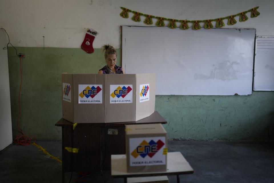A woman casts her vote during a referendum about the future of a disputed territory with Guyana, at a polling station in Caracas, Venezuela, Sunday, Dec. 3, 2023. (AP Photo/Ariana Cubillos)