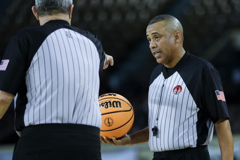 Referee Darrell Monroe, right, hold the ball during a stoppage in play Thursday during a Class B boys state quarterfinal at State Fair Arena.