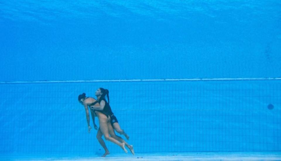 USA Artistic Swimming team member Anita Alvarez is pulled toward the surface by her coach Andrea Fuentes after fainting at the end of her solo routine at the World Aquatic Championships in Budapest, Hungary, June 22, 2022. / Credit: AFP/Getty