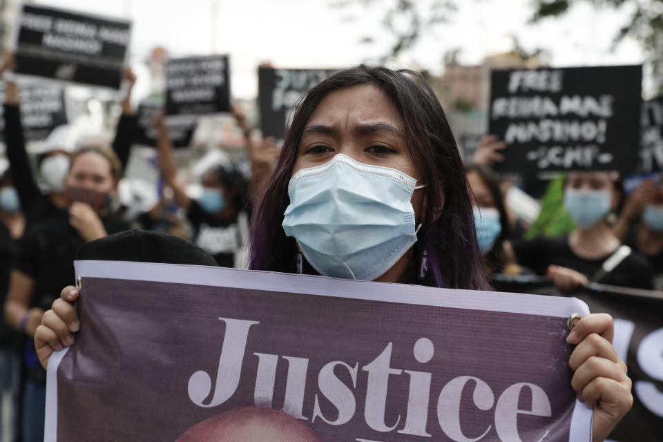 Protesters hold slogans during a rally outside Manila's North Cemetery, Philippines where detained left-wing activist Reina Mae Nasino attends funeral rites of her three-month-old firstborn named River on Friday Oct. 16, 2020. Left-wing groups on Friday decried as brutal the treatment of a detained activist, who was allowed by a Manila court to attend her baby's burial but was restrained with handcuffs, a sweltering protective suit and swarms of armed escorts as she quietly wept. (AP Photo/Aaron Favila)