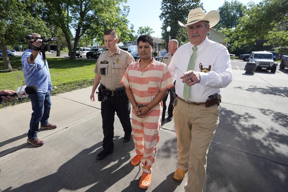 Francisco Oropeza, center, is escorted to the San Jacinto County courthouse by San Jacinto County Sheriff Greg Capers, right, for a hearing Thursday, May 18, 2023, in Coldspring, Texas. Oropeza is suspected of killing five people, including a 9-year-old boy, after neighbors asked him to stop firing off rounds in his yard. (AP Photo/David J. Phillip)