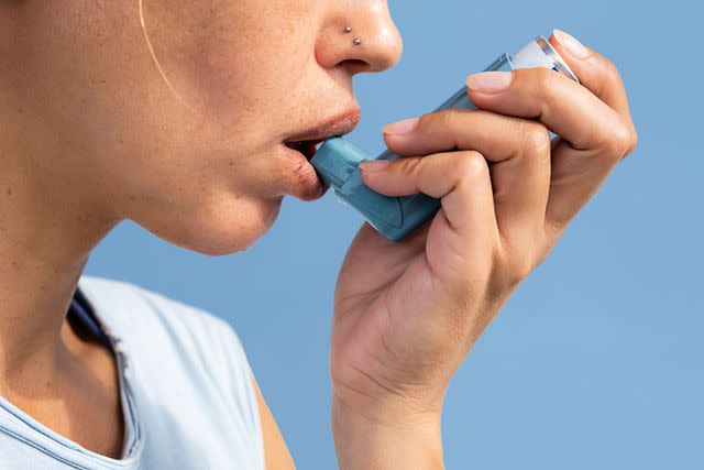 <p>Getty</p> Stock image of a woman using an asthma inhaler.