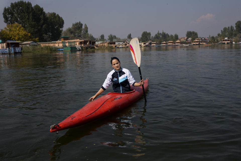 In this Friday, Oct. 25, 2019, photo, a Kashmiri kayaker Mehak Peer, 26, sits for a photograph during her first practice session since Aug. 5, on the Dal Lake in Srinagar, Indian-controlled Kashmir. “Because of the lockdown and internet blockade we have missed three tournaments. I was hoping to make it to the international level but after missing these national tournaments, that is no longer possible,” Peer said. (AP Photo/ Dar Yasin)