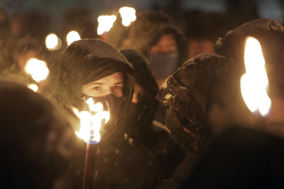 Bulgarian far-right nationalists hold torches as they gathered in the country's capital, to honour a World War II general known for his anti-Semitic and pro-Nazi activities, in Sofia, Saturday, Feb. 13, 2021. Braving sub-zero temperatures, hundreds of dark-clad supporters of the Bulgarian National Union group flocked to a central square where they had planned to kick off the annual Lukov March, a torch-lit procession held every February to the former house of Gen. Hristo Lukov. (AP Photo/Valentina Petrova)