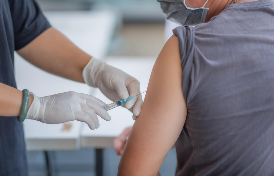 The doctor is injecting male patients.In the medical's hand have syringes.