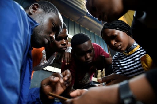 Code for Africa's John Eromosele, left, teaches volunteers how to use the app for the digital mapping project