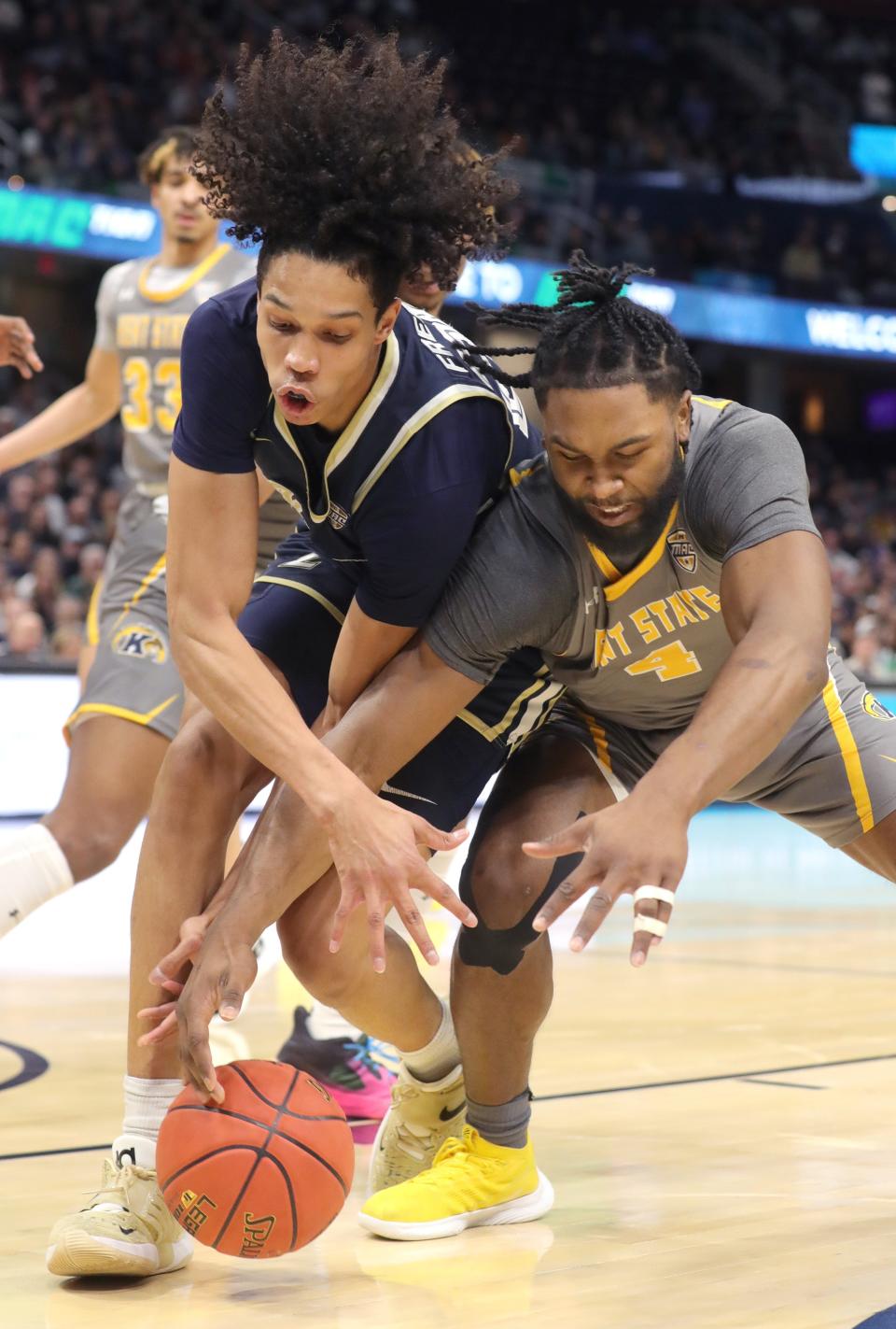 University of Akron forward Enrique Freeman, left, and Kent State's Andrew Garcia go after a loose ball in the Mid American Conference championship game Saturday at Rocket Mortgage FieldHouse in Cleveland. [Phil Masturzo/ Beacon Journal]