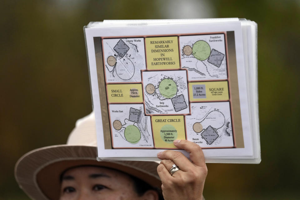 Park Ranger Myra Vick holds up diagrams of Hopewell Earthworks during a tour of the Mound City Group at Hopewell Culture National Historical Park in Chillicothe, Ohio, Saturday, Oct. 14, 2023, before the Hopewell Ceremonial Earthworks UNESCO World Heritage Inscription Commemoration ceremony. A network of ancient American Indian ceremonial and burial mounds in Ohio noted for their good condition, distinct style and cultural significance, including Hopewell, was added to the list of UNESCO World Heritage sites. (AP Photo/Carolyn Kaster)